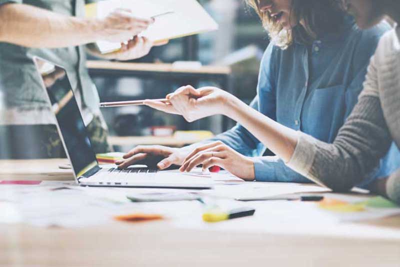 Colleagues work on a laptop